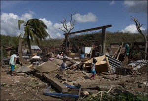 Residents walk through the debris of homes destroyed by Hurricane Patricia, in Chamela, Mexico, Saturday, Oct. 24, 2015. Record-breaking Patricia pushed rapidly inland over mountainous western Mexico early Saturday, weakening to tropical storm force while dumping torrential rains that authorities warned could cause deadly floods and mudslides. (AP Photo/Rebecca Blackwell)